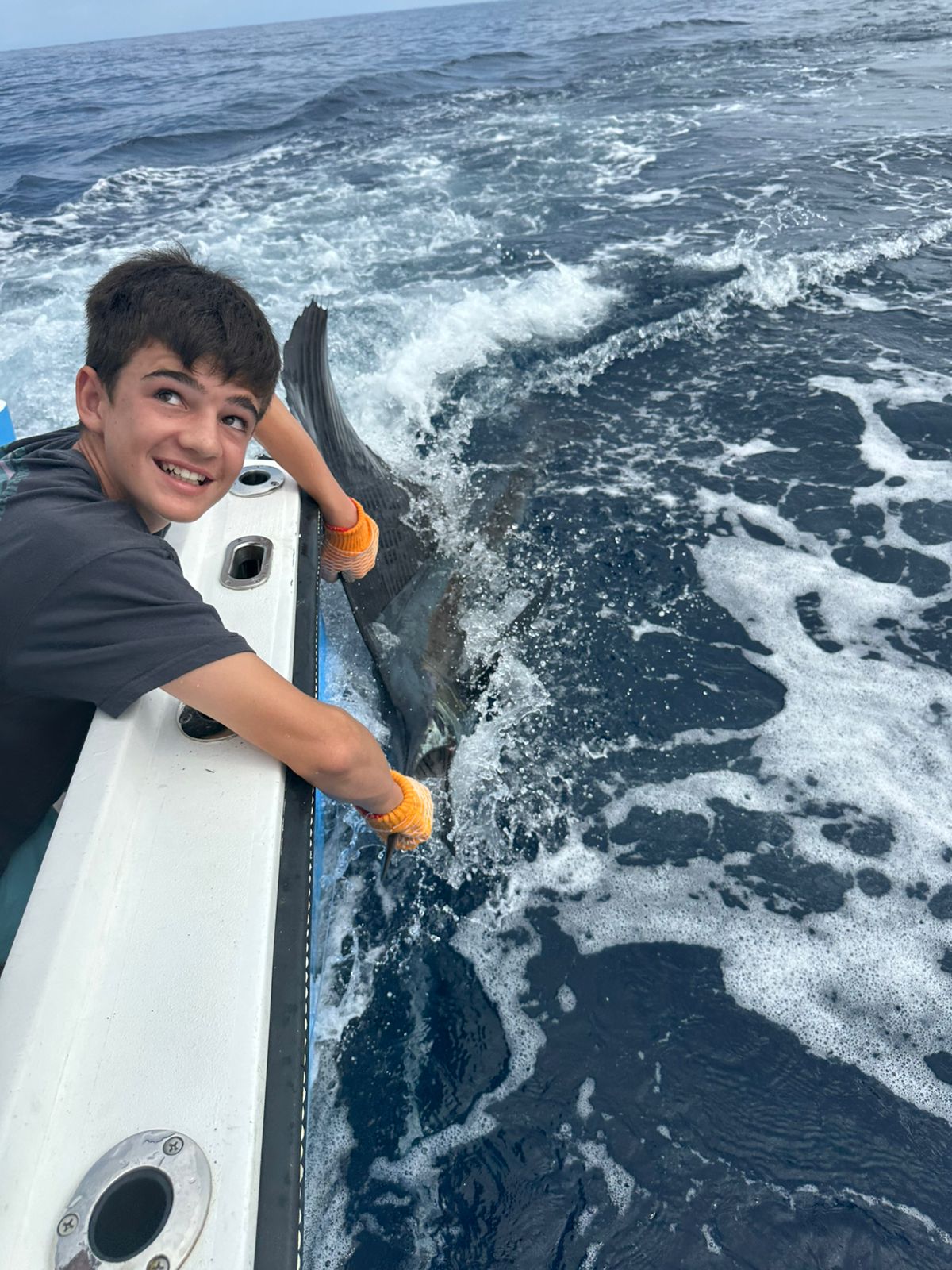 Young angler releasing marlin